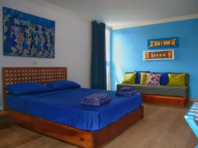 a bedroom with a bed and a couch at Suite Mariposa Sospesa Sul Mare in Mindelo
