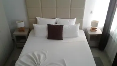 a bed with white sheets and pillows in a room at Vista Mar in Tarrafal