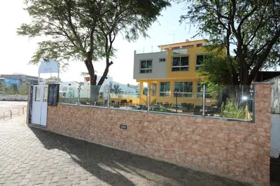 a brick wall with a door in front of a building at Vista Mar in Tarrafal