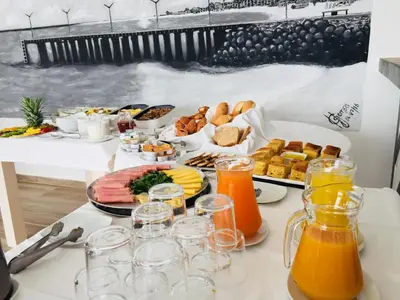 a table topped with plates of food and orange juice at Hotel LIVVO Budha Beach in Santa Maria