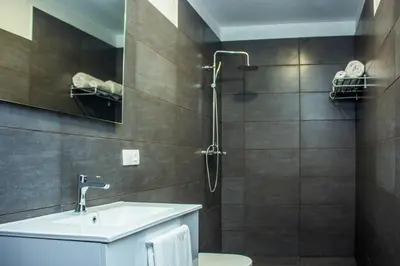 a bathroom with a toilet and a sink and a shower at Hotel LIVVO Budha Beach in Santa Maria