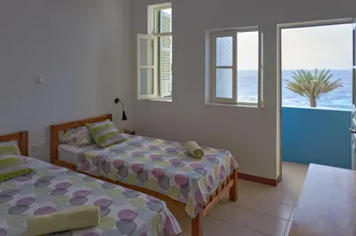a bedroom with two beds and a view of the ocean at Música do Mar in Ponta do Sol