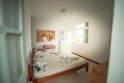 a bedroom with a bed in a room with a window at Música do Mar in Ponta do Sol