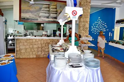 a table with white plates on it in a kitchen at Porto Antigo Hotel BB in Santa Maria