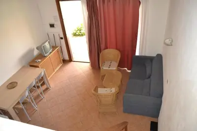 a living room with a blue couch and a table at Porto Antigo Hotel BB in Santa Maria