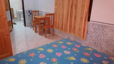 a bedroom with a bed and a table and chairs at Basic Hotel in Mindelo
