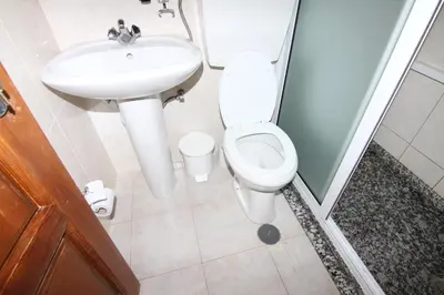 a bathroom with a toilet and a sink at Restaurante Residencial Nova Cidade in Porto Novo