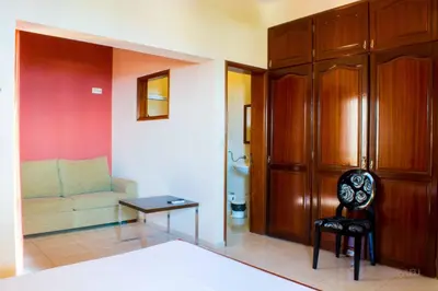 a living room with a couch and a chair at Restaurante Residencial Nova Cidade in Porto Novo