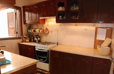 a kitchen with wooden cabinets and a stove top oven at Private Holiday Apartment in Tarrafal