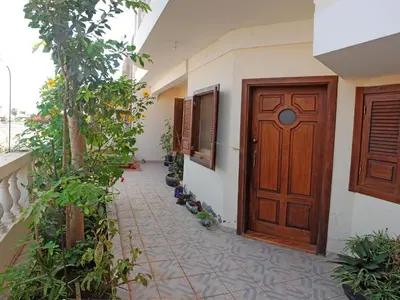 a hallway with a wooden door and some plants at Private Holiday Apartment in Tarrafal