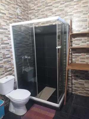 a bathroom with a toilet and a glass shower at Appart Chris Mindelo in Mindelo