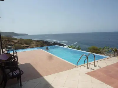 a swimming pool with a view of the ocean at Villa Halcyon Caboverde in Cidade Velha