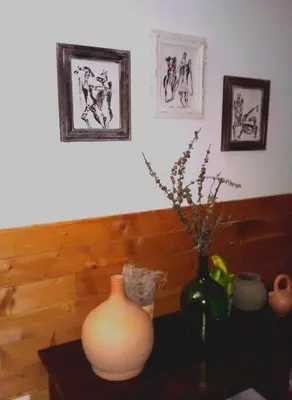 a vase sitting on a table with two pictures on the wall at My Place Apt#1 in Praia