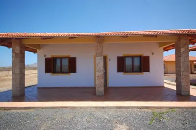 a small white house with two windows and a roof at Villa Maris Ecolodge in Morro