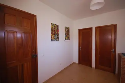 an empty room with two wooden doors and tile floors at Villa Maris Ecolodge in Morro