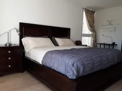 a bedroom with a bed and a dresser and a window at @Georgette in Mindelo