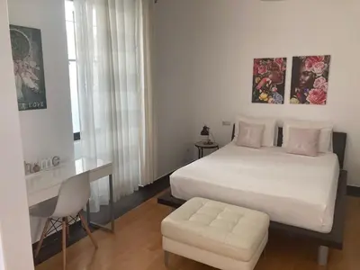 a bedroom with a bed and a desk and a chair at Casa Senador in Mindelo