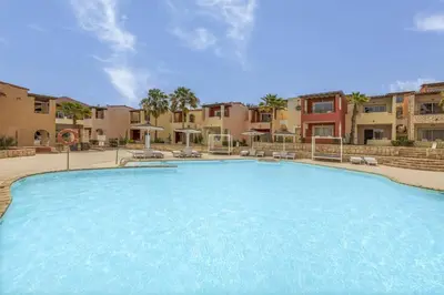 a large swimming pool with chairs and buildings in the background at Occidental Boa Vista Beach in Rabil