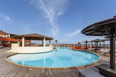 a pool at a resort with tables and umbrellas at Occidental Boa Vista Beach in Rabil