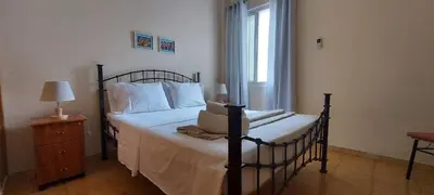 a bedroom with a bed with white sheets and a window at Apt. Idilfa in Praia