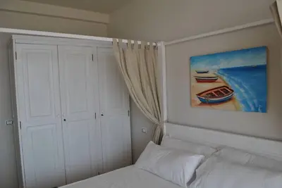 a bedroom with a bed and a painting of a boat at Ca Madeira - 2bedroom, sea view & wifi in Sal Rei