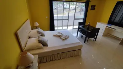 a room with a bed with a desk and a window at Pousada B&B Le Gourmet in São Pedro