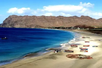 a beach with boats on the sand and the water at Pousada B&B Le Gourmet in São Pedro
