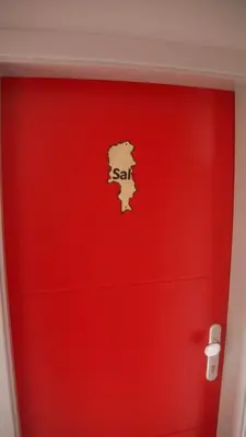 a red wall with a red door with a sign on it at Pousada B&B Le Gourmet in São Pedro