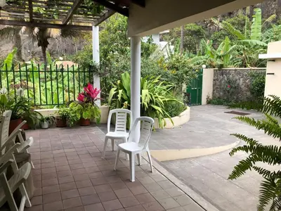 a patio with two white chairs and plants at Ribeira Grande Country House in Escabeçada