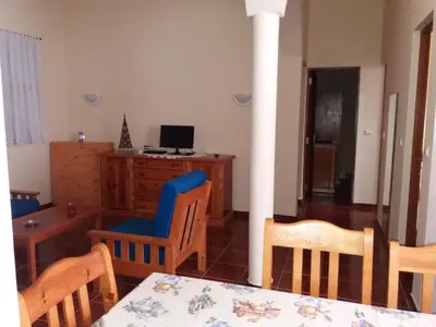 a living room with a table and chairs and a computer at Ribeira Grande Country House in Escabeçada