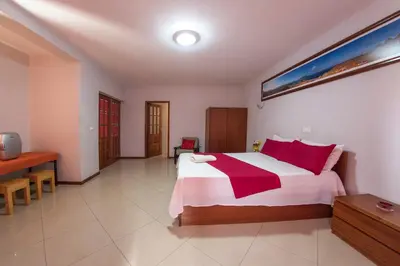 a bedroom with a large bed with red pillows at Laginha Beach Guest House in Mindelo