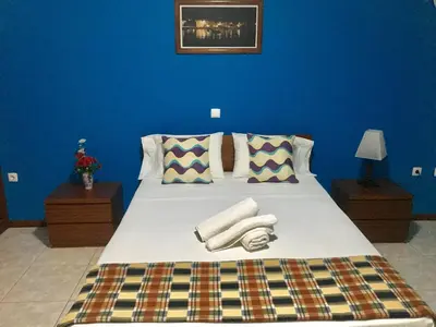 a blue bedroom with a bed with towels on it at Laginha Beach Guest House in Mindelo