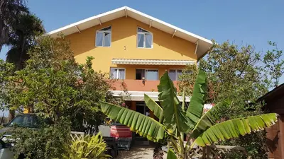 a yellow house with trees in front of it at Cote de France in Fundura