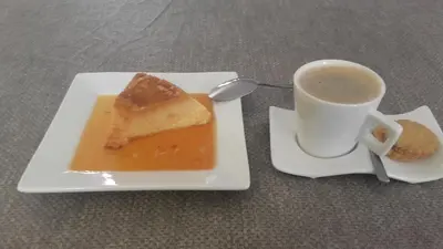 a plate with a piece of cake and a cup of coffee at Cote de France in Fundura