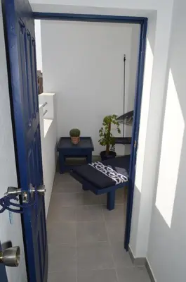 a hallway with a blue door and a bench at Yacht Club Sal in Palmeira