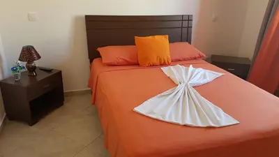 a bedroom with a bed with a dress on it at Hotel Ocean View & Restaurante Seafood in São Filipe