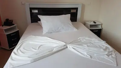 a white bed with a bow on top of it at Hotel Ocean View & Restaurante Seafood in São Filipe