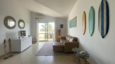 a living room with a couch and surfboards on the wall at Sal Apartments Djadsal Moradias in Santa Maria