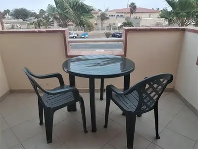 a table and two chairs on a balcony at Sal Apartments Djadsal Moradias in Santa Maria