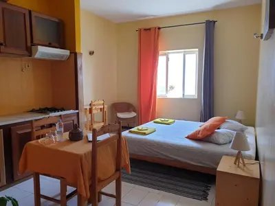 a bedroom with a bed and a table and a window at Casa D'Mar in Ponta do Sol