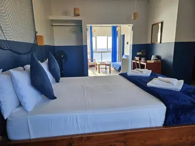 a bedroom with a large bed with blue walls at kasa Tambla in Ponta do Sol