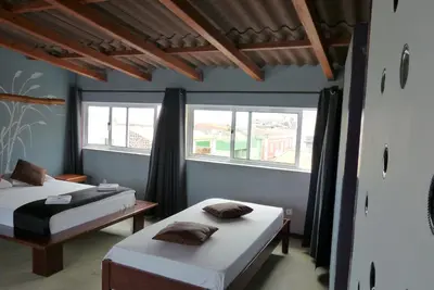 two beds in a room with two windows at kasa Tambla in Ponta do Sol