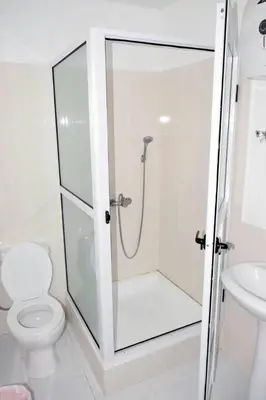 a bathroom with a shower with a toilet and a sink at Hotel Miramar Fogo Brava in São Filipe