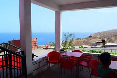 a table and chairs on a balcony with a view of the ocean at Hotel Miramar Fogo Brava in São Filipe