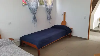 a room with a bed with a blue blanket on it at Casa Patio in Tarrafal