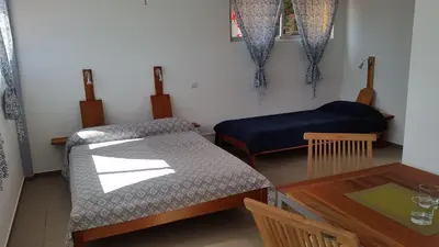 a room with a table and a bed and a table and a chair at Casa Patio in Tarrafal
