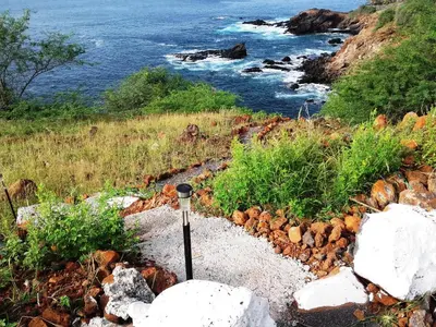 a pole in the rocks next to the ocean at Pousada Villa Concetta AC in Cidade Velha