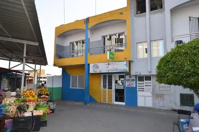 a building with a fruit market in front of it at Apartamento Rita in Praia
