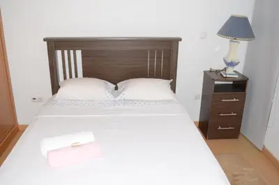 a bedroom with a bed and a nightstand with a lamp at Apartamento Rita in Praia