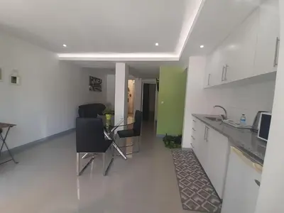 a kitchen with a table and chairs in a room at Apto T1 Comfort in Praia
